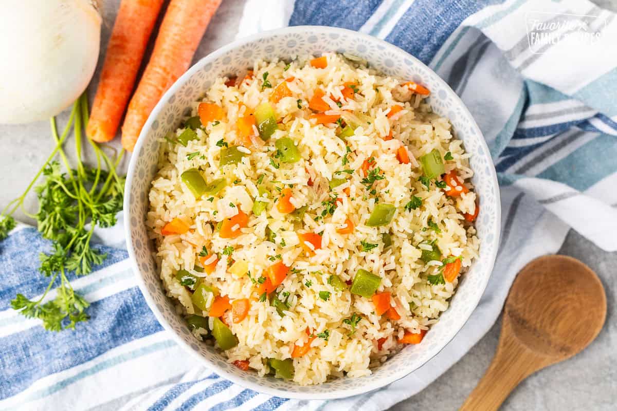 Bowl of Vegetable rice with green peppers, carrot and onion. Garnished with fresh parsley.