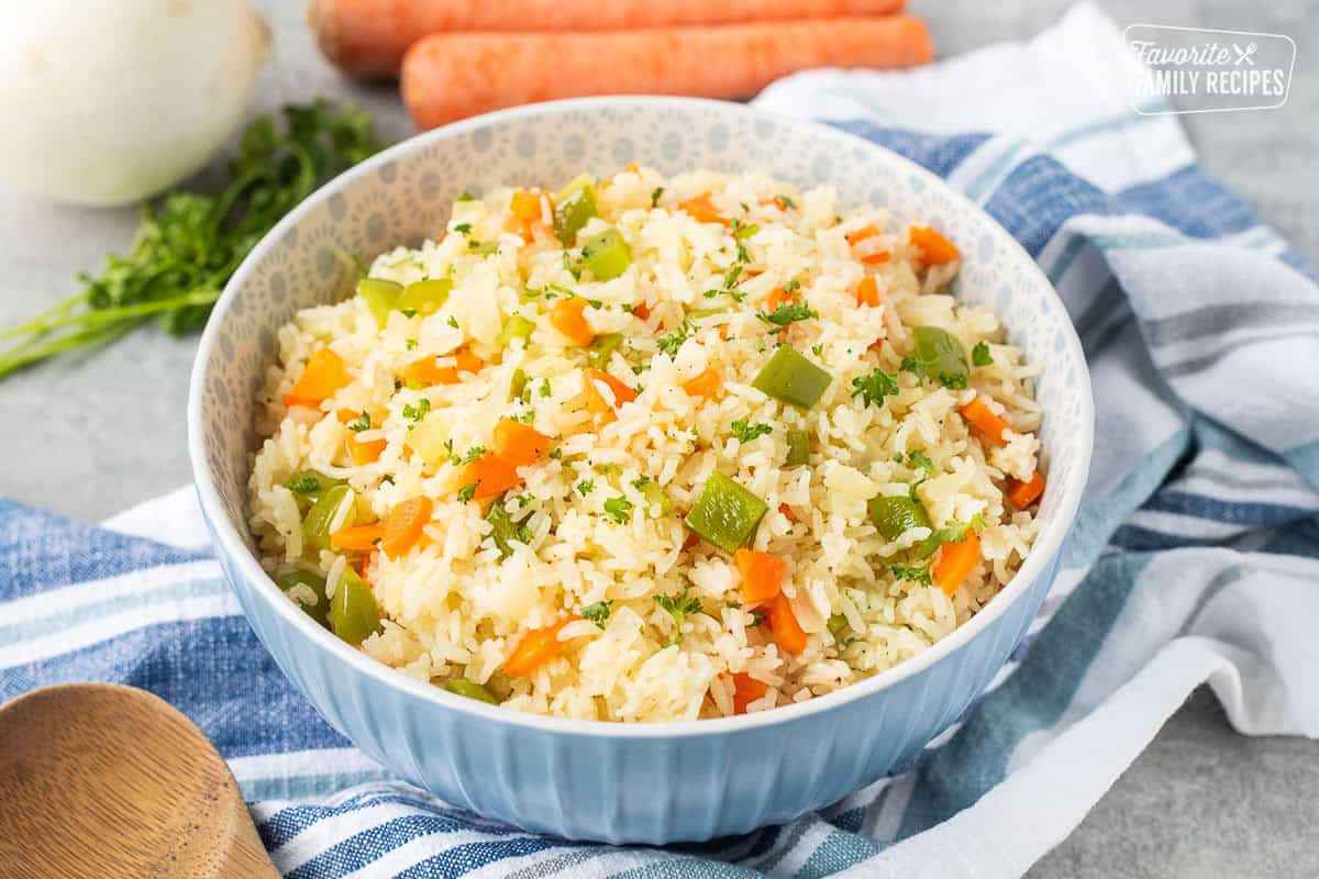 Bowl of Vegetable rice with green peppers, carrot and onion. Garnished with fresh parsley.
