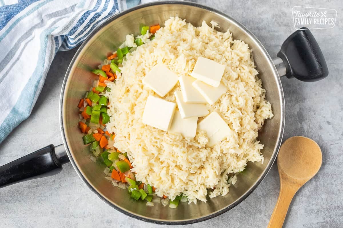 Adding rice into skillet of vegetables and butter.
