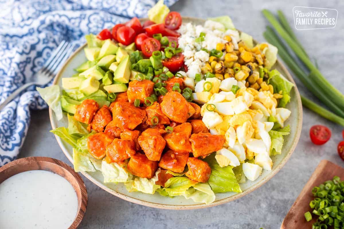 Buffalo chicken salad with lettuce, avocado, hard boiled egg, fire roasted corn, blue cheese, halved cherry tomatoes, green onions and diced chicken with Frank's red hot sauce. Ranch dressing on the side.