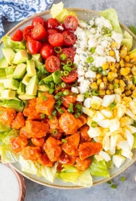Buffalo chicken salad with lettuce, avocado, hard boiled egg, fire roasted corn, blue cheese, halved cherry tomatoes, green onions and diced chicken with Frank's red hot sauce. Ranch dressing on the side.