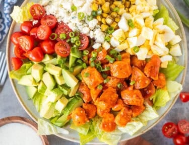 Buffalo chicken salad with lettuce, avocado, hard boiled egg, fire roasted corn, blue cheese, halved cherry tomatoes, green onions and diced chicken with Frank's red hot sauce. Ranch dressing on the side.