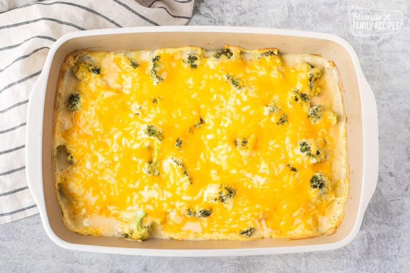 Melted cheese on top of cooked chicken divan in a casserole dish.