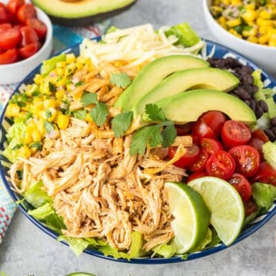 Southwest Chicken Salad with lettuce, Mexican shredded chicken, tomatoes, black beans, corn salad, avocado, tortilla strips, cilantro and Monterey Jack cheese. Cilantro lime salad dressing on the side.