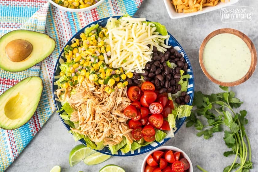 Salad bowl of lettuce, Mexican shredded chicken, tomatoes, black beans, corn salad and Monterey Jack cheese.