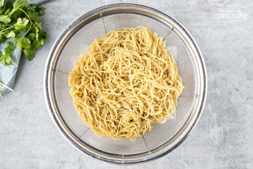 Straining cooked yaki soba noodles.