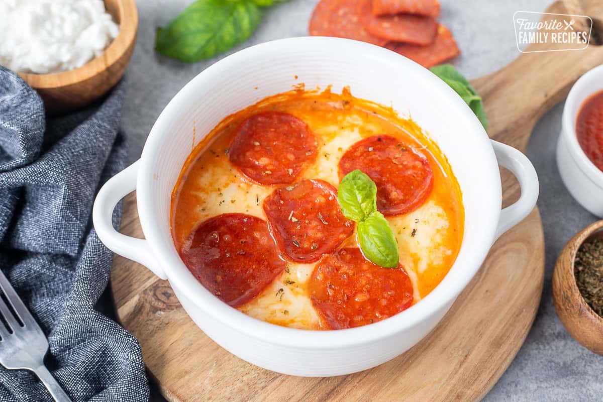 Cottage cheese pepperoni pizza bowl garnished with fresh basil.