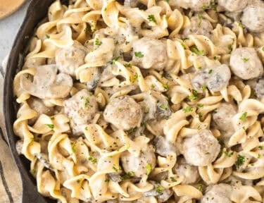 Creamy meatball stroganoff mixed with noodles in a skillet.