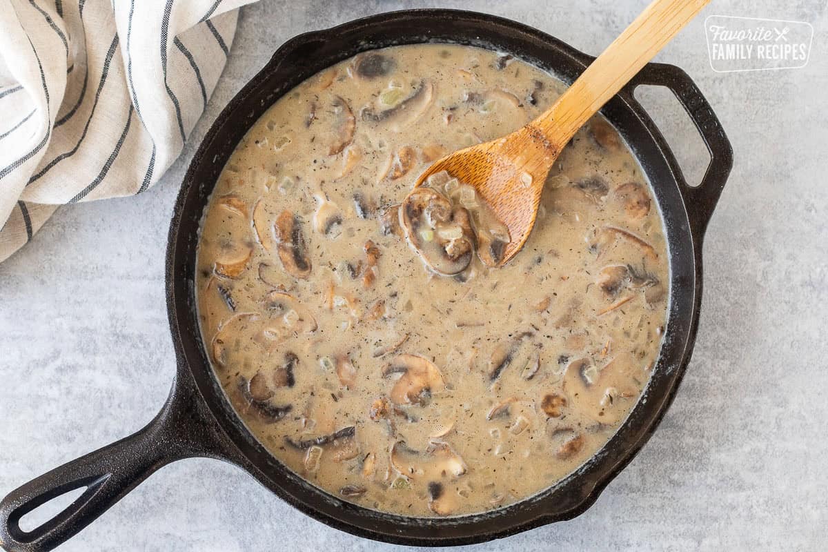 Beef broth in creamy stroganoff mixture in skillet.
