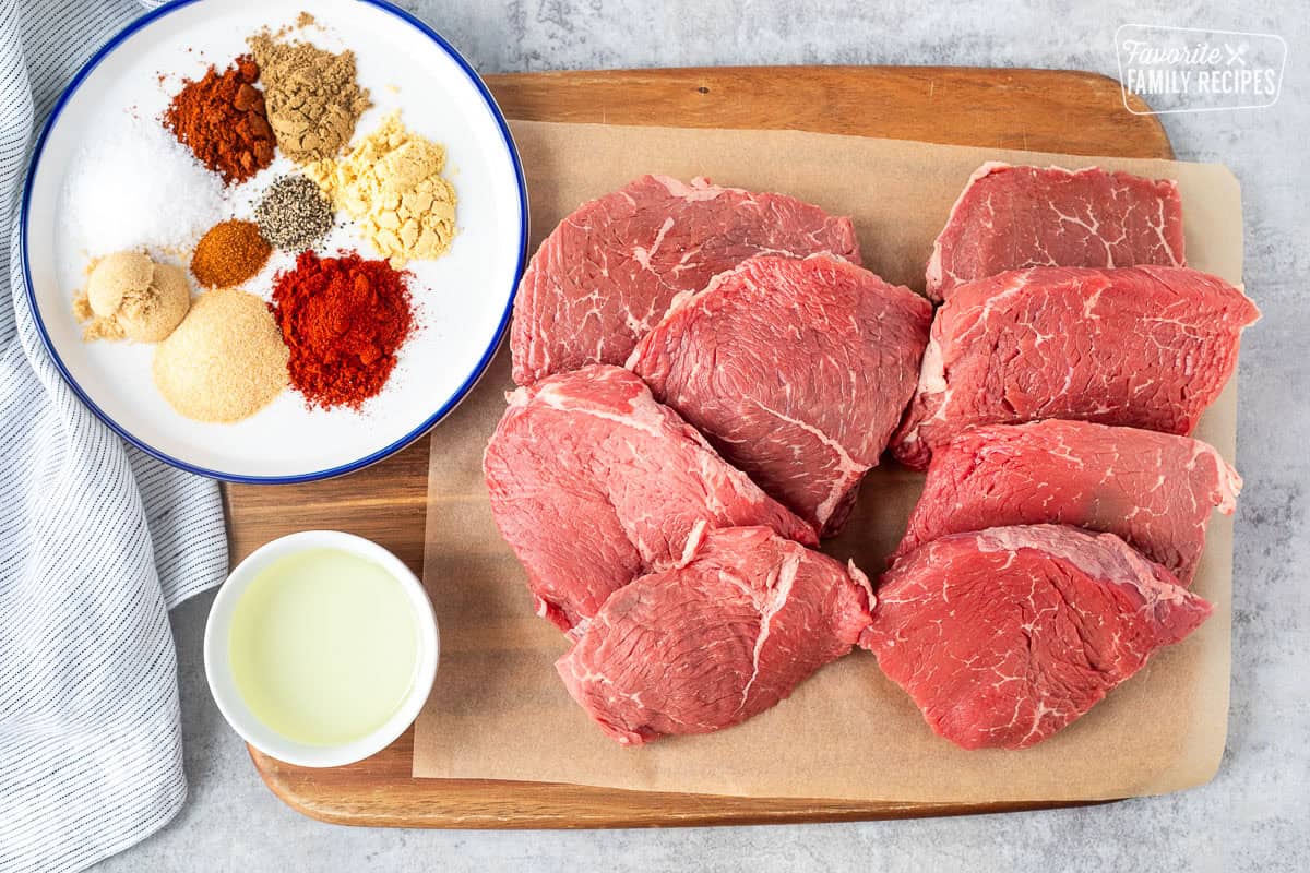 Ingredients to make Frozen Sliced Steak including steak, oil, garlic powder, salt, brown sugar, paprika, cumin, pepper, cayenne pepper, ground mustard and chili powder.