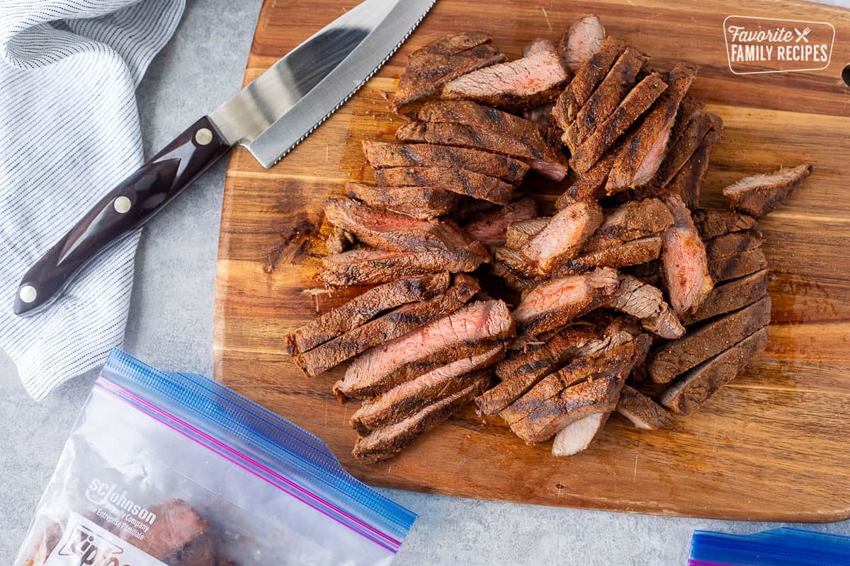 Placing sliced steak into a freezer ziplock bag.