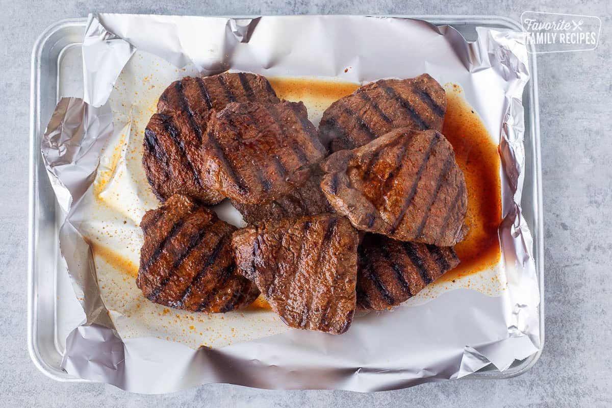Grilled steaks resting on foil.