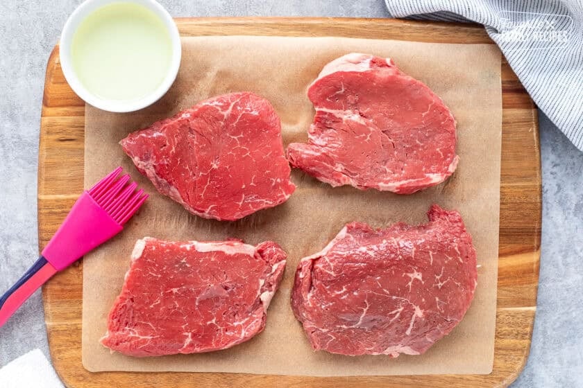 Brushing oil on steak.