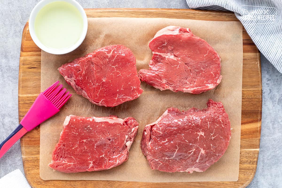 Brushing oil on steak.