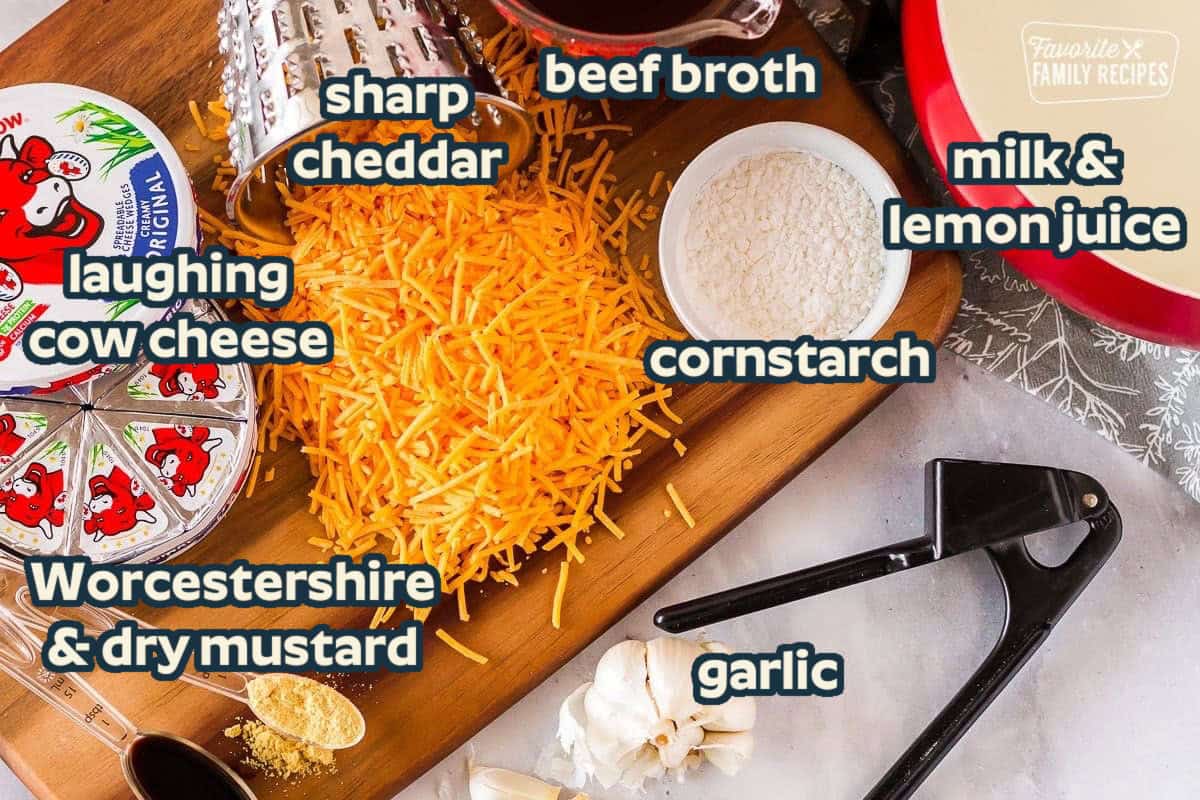 Ingredients to make Cheddar Cheese Fondue including sharp cheddar, laughing cow cheese, cornstarch, beef broth, garlic, Worcestershire, and milk