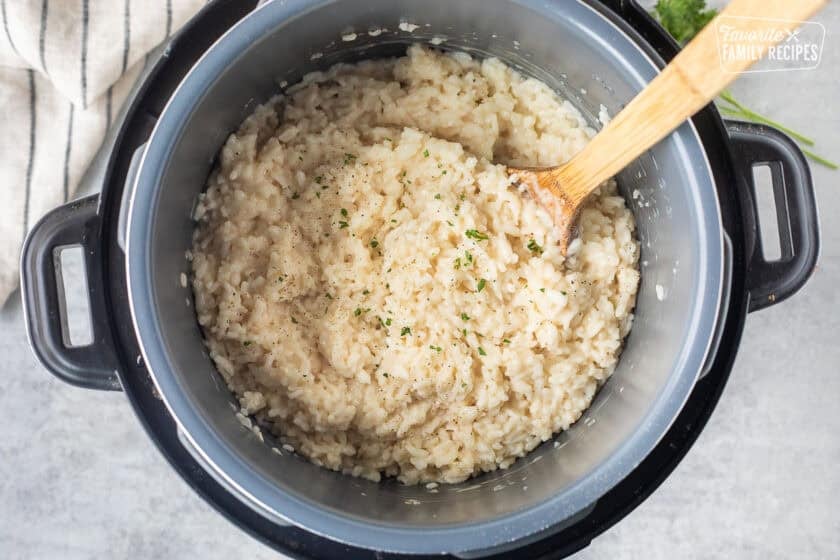 Instant pot risotto garnished with fresh parsley, salt and pepper.