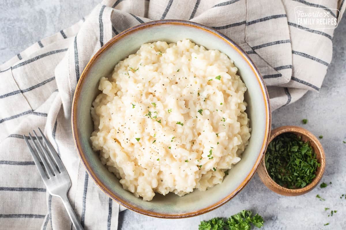 Bowl of instant pot risotto garnished with parsley and pepper.