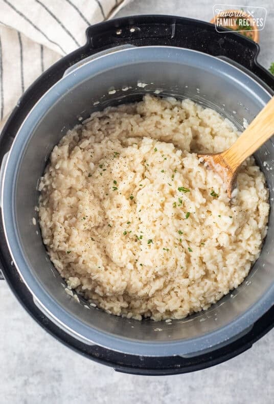 Instant pot risotto garnished with fresh parsley, salt and pepper.