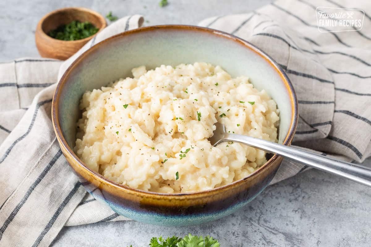 Fork resting in a bowl of instant pot risotto.