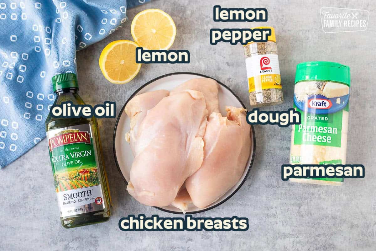 Ingredients to make lemon pepper chicken including grated parmesan cheese, lemon pepper, chicken breasts and olive oil.