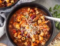 Spoon resting in a bowl full of Pasta e Fagioli.