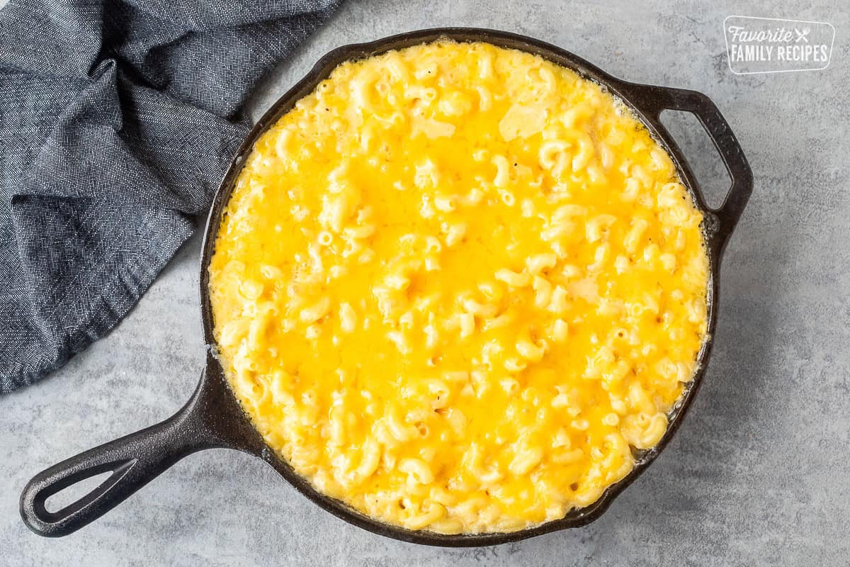 Baked macaroni and cheese in a cast iron skillet that has been baked. The cheese is melted over the top to make a nice cheese topping.