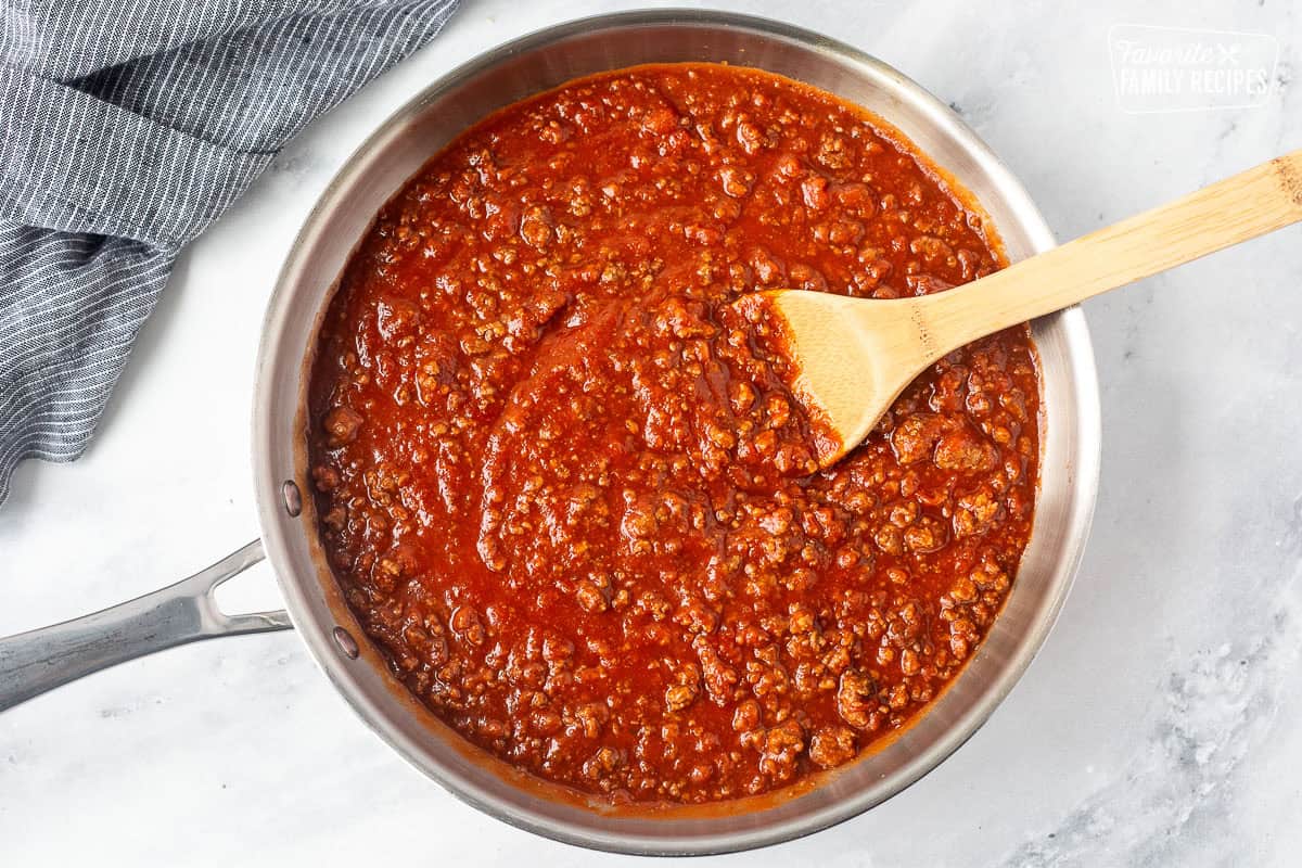 Skillet with sloppy Joe mixture and wooden spoon.