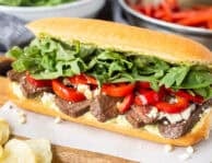 Steak Sandwich on a French roll with pesto mayo, red pepper, blue cheese crumbles, arugula and spinach mix.