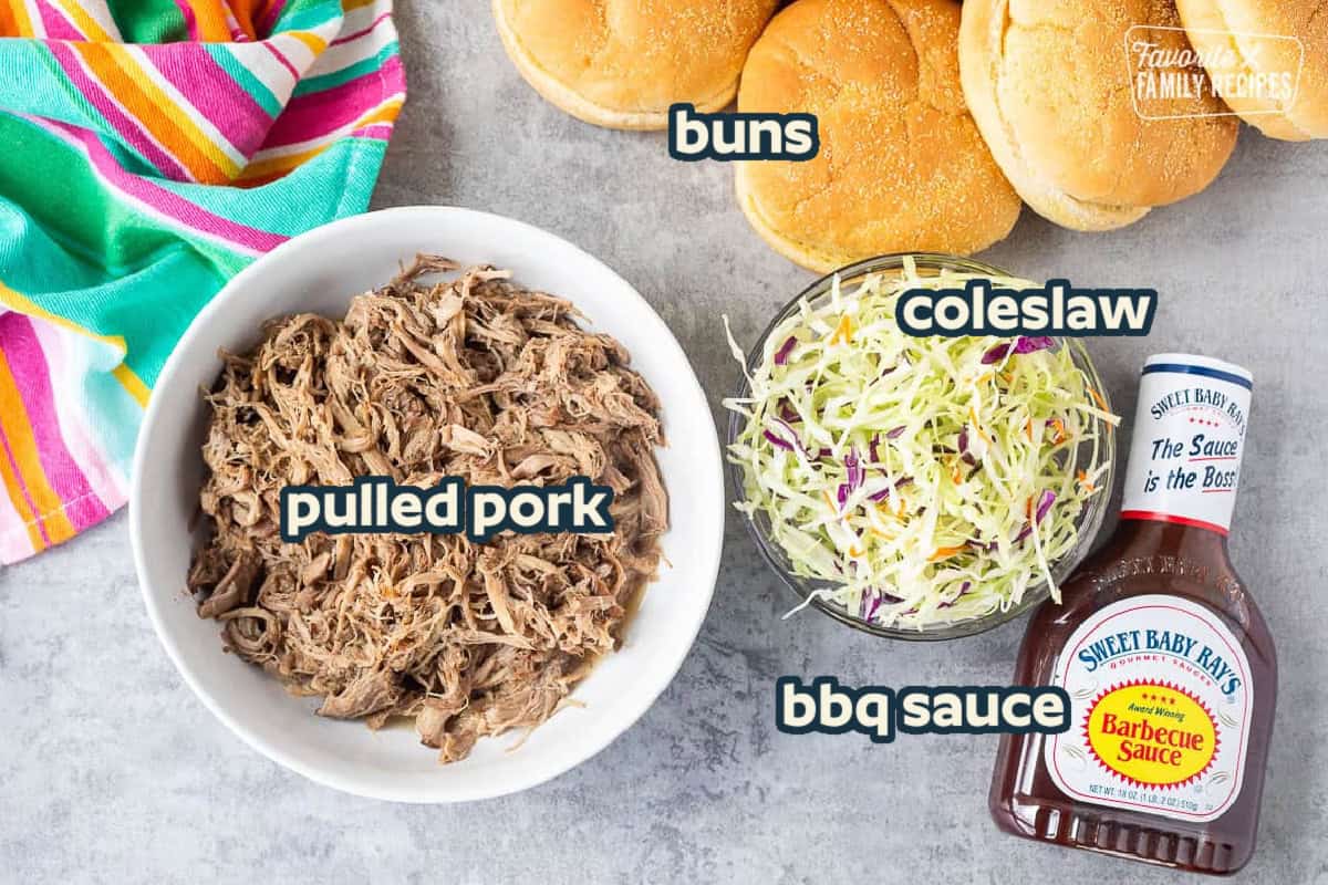 Ingredients to make a BBQ pulled pork sandwich. Including pulled pork, buns, coleslaw, and bbq sauce.