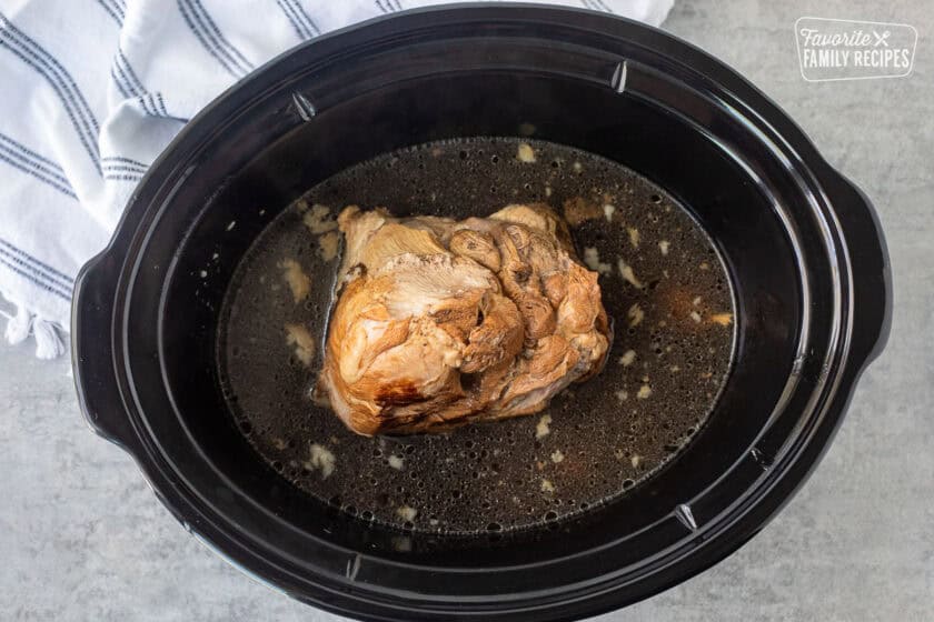 Crockpot with cooked pork roast.