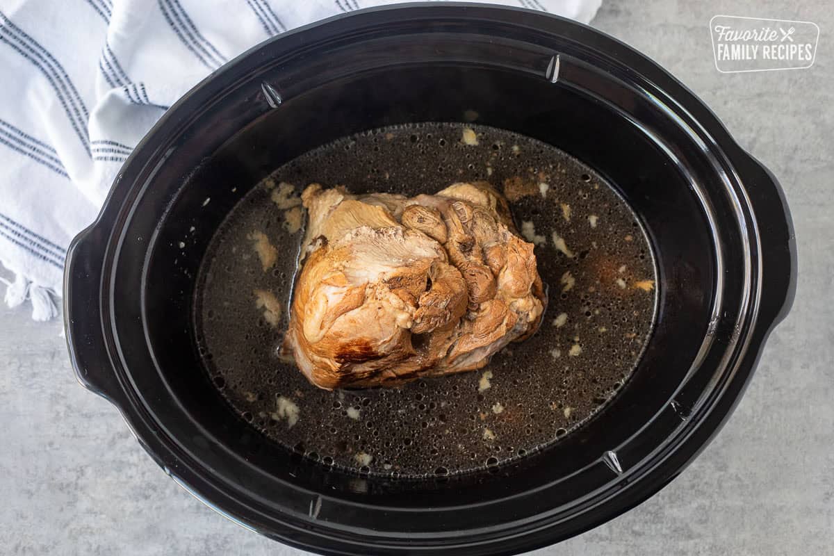 Crockpot with cooked pork roast.