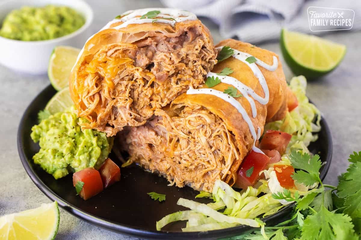 Chicken Chimichanga cut open with sour cream drizzled on top and cilantro.