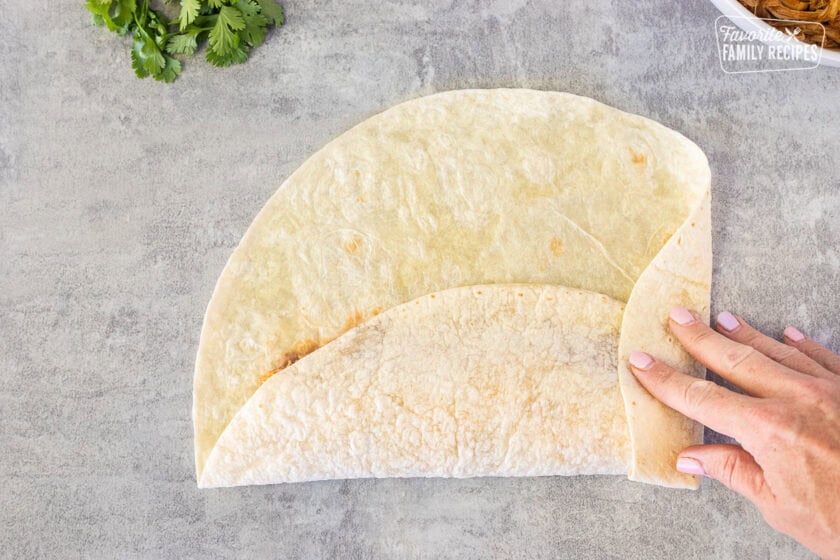 Folding a flour tortilla.
