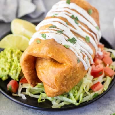 Chicken Chimichanga garnished with sour cream drizzled on top and cilantro.