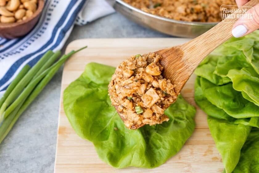 Placing chicken filling onto lettuce leaf that resembles the filling at PF Changs.