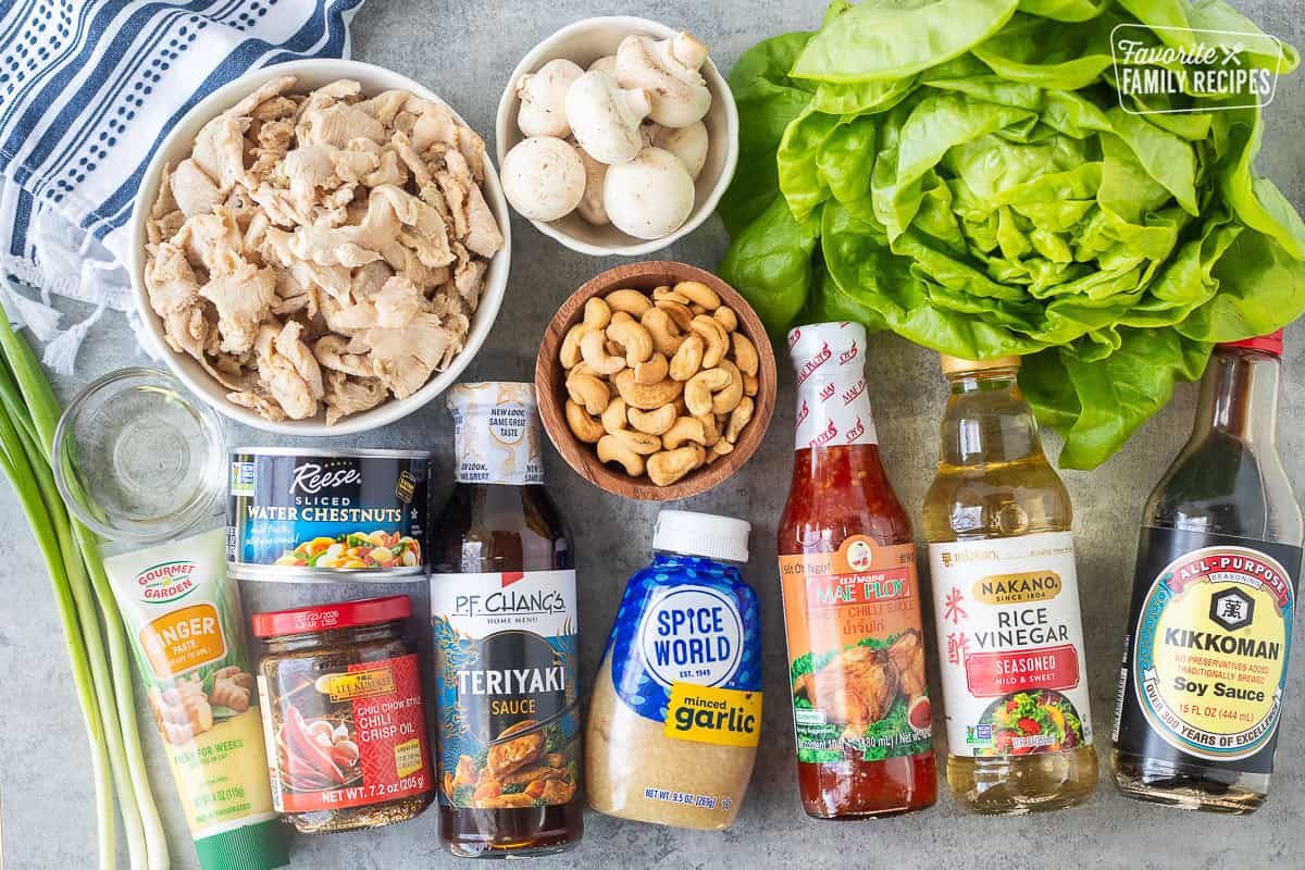 Ingredients to make PF Changs chicken lettuce wraps including butter lettuce, soy sauce, rice vinegar, sweet chili sauce, minced garlic, teriyaki sauce, cashews, mushrooms, chili crisp oil, water chestnuts, green onion, ginger paste, oil and velvet chicken.
