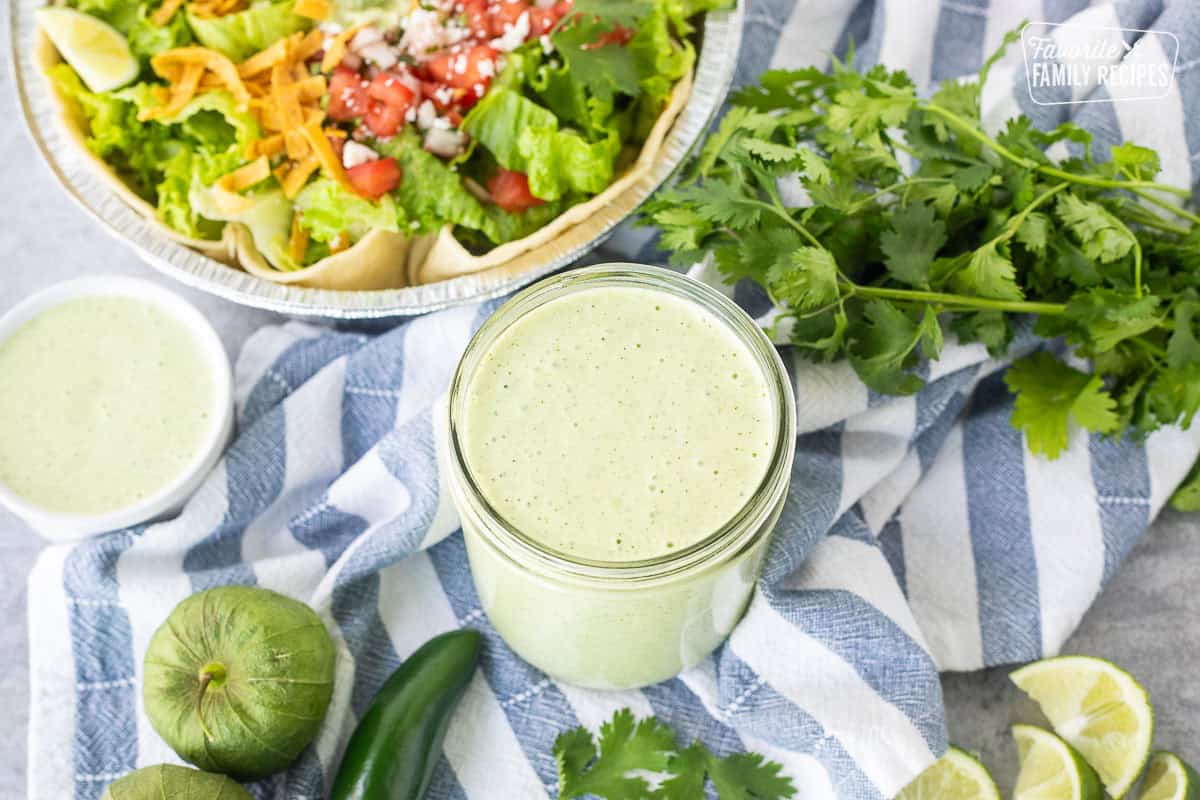 Jar of cCafe Rio Creamy Tomatillo Ranch Dressing next to a Cafe Rio salad.