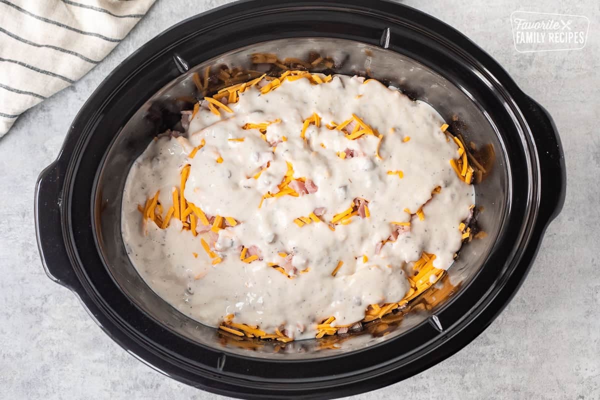 Cream of mushroom soup mixture poured on top of layered ham, potatoes and cheese.