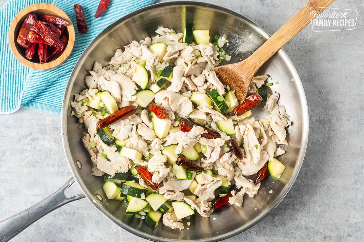 Skillet with velvet chicken, zucchini, chilies and green onion.