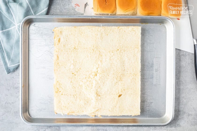 Hawaiian rolls cut in half on sheet pan.