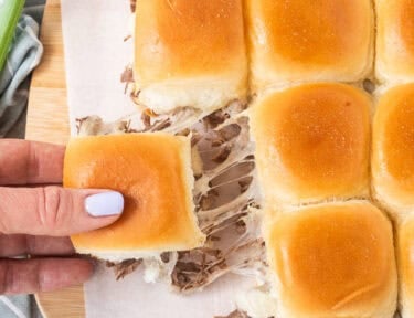 Pulling a roast beef slider that was connected to the other sliders with the cheese pulling.