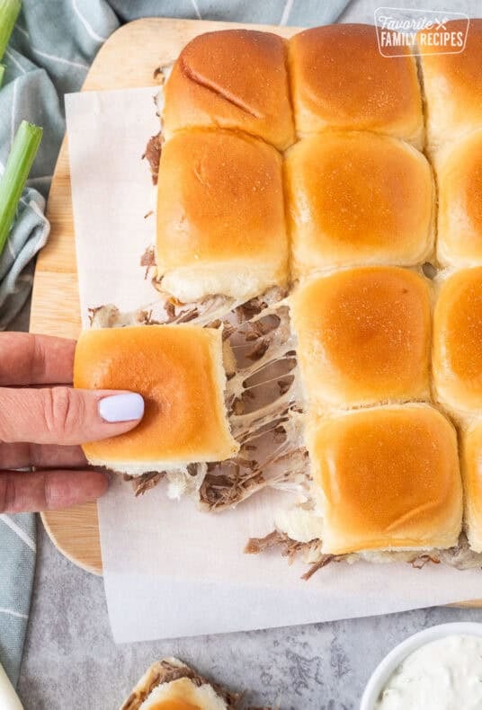 Pulling a roast beef slider that was connected to the other sliders with the cheese pulling.