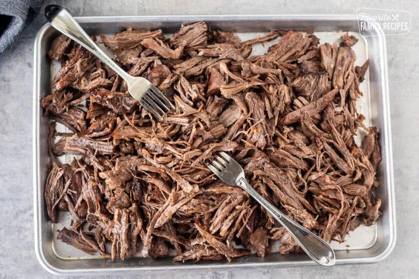 Shredding cooked beef roast with two forks.