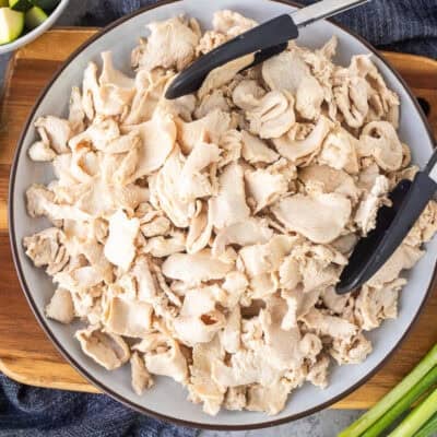 Velvet chicken on a plate with tongs.