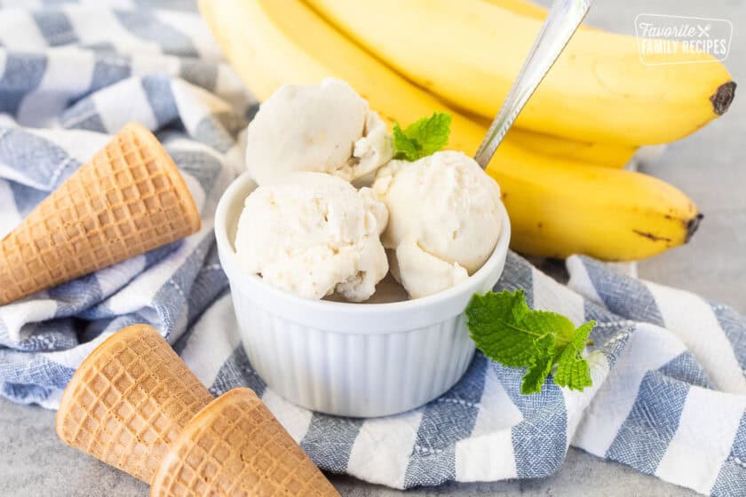 Three scoops of banana ice cream in a small dish and a spoon.