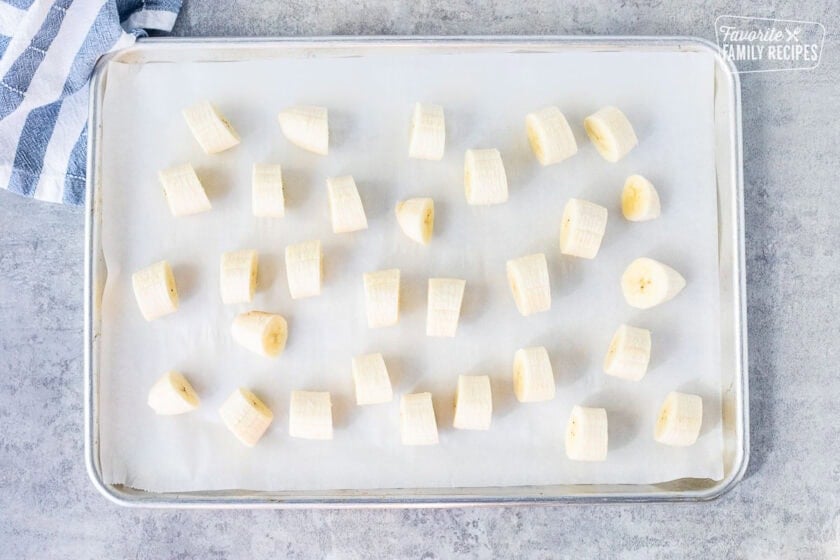 Sheet pan lined with parchment paper and cut pieces of banana.