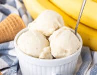 Three scoops of banana ice cream in a small dish and a spoon.