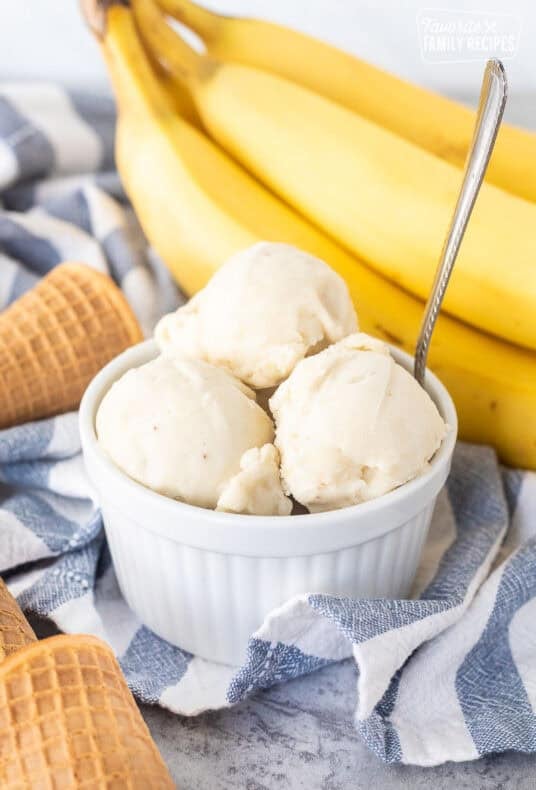 Three scoops of banana ice cream in a small dish and a spoon.