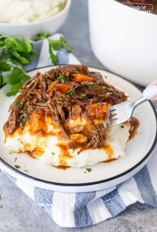 Plate of beef goulash over mashed potatoes.