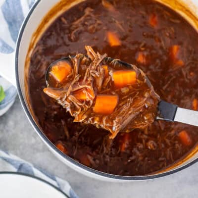 Spoon full of Beef Goulash with carrots in a serving spoon.